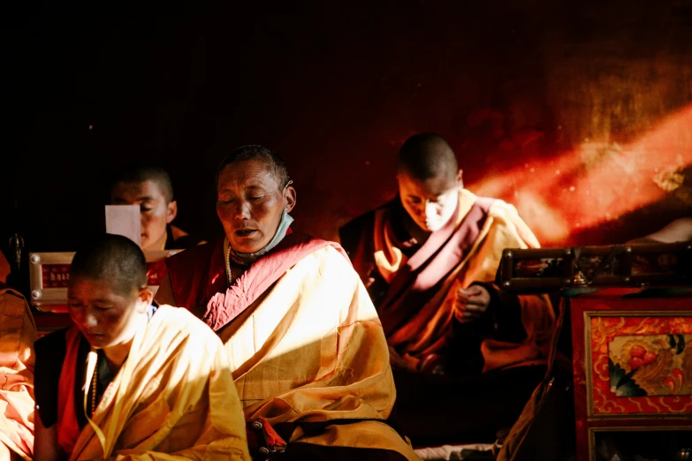 a bunch of monks are gathered together, all sitting on the ground