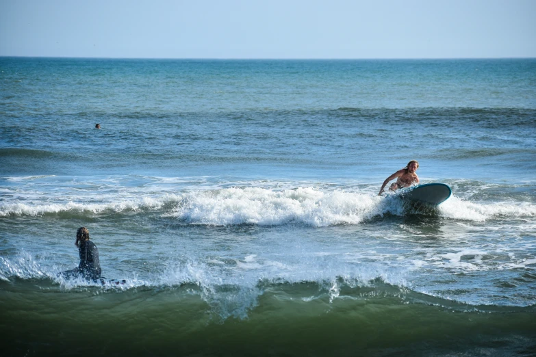 two people surfing on the ocean waves together