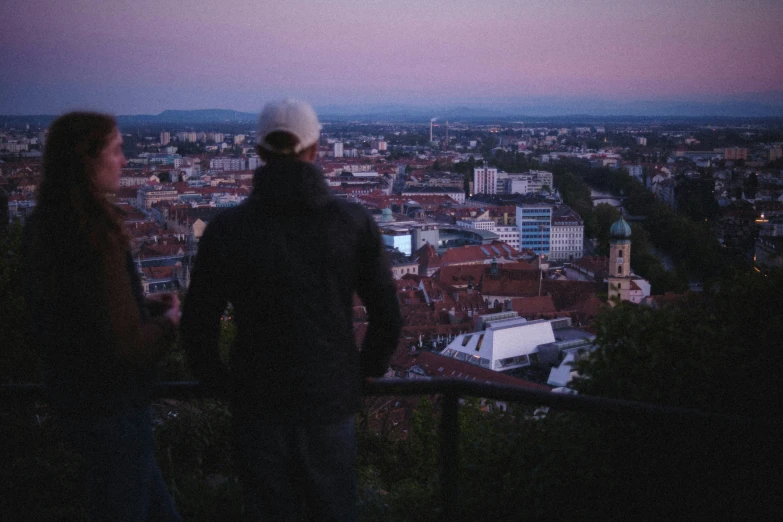 two people are standing on the balcony at night