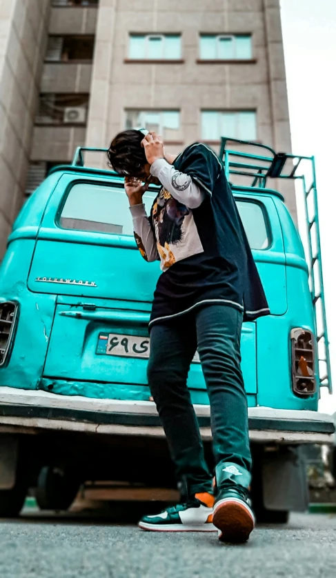 a man is standing next to an old green truck