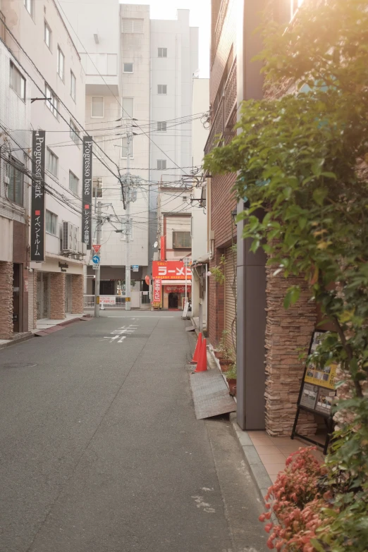 the street in the city has a sign and some buildings