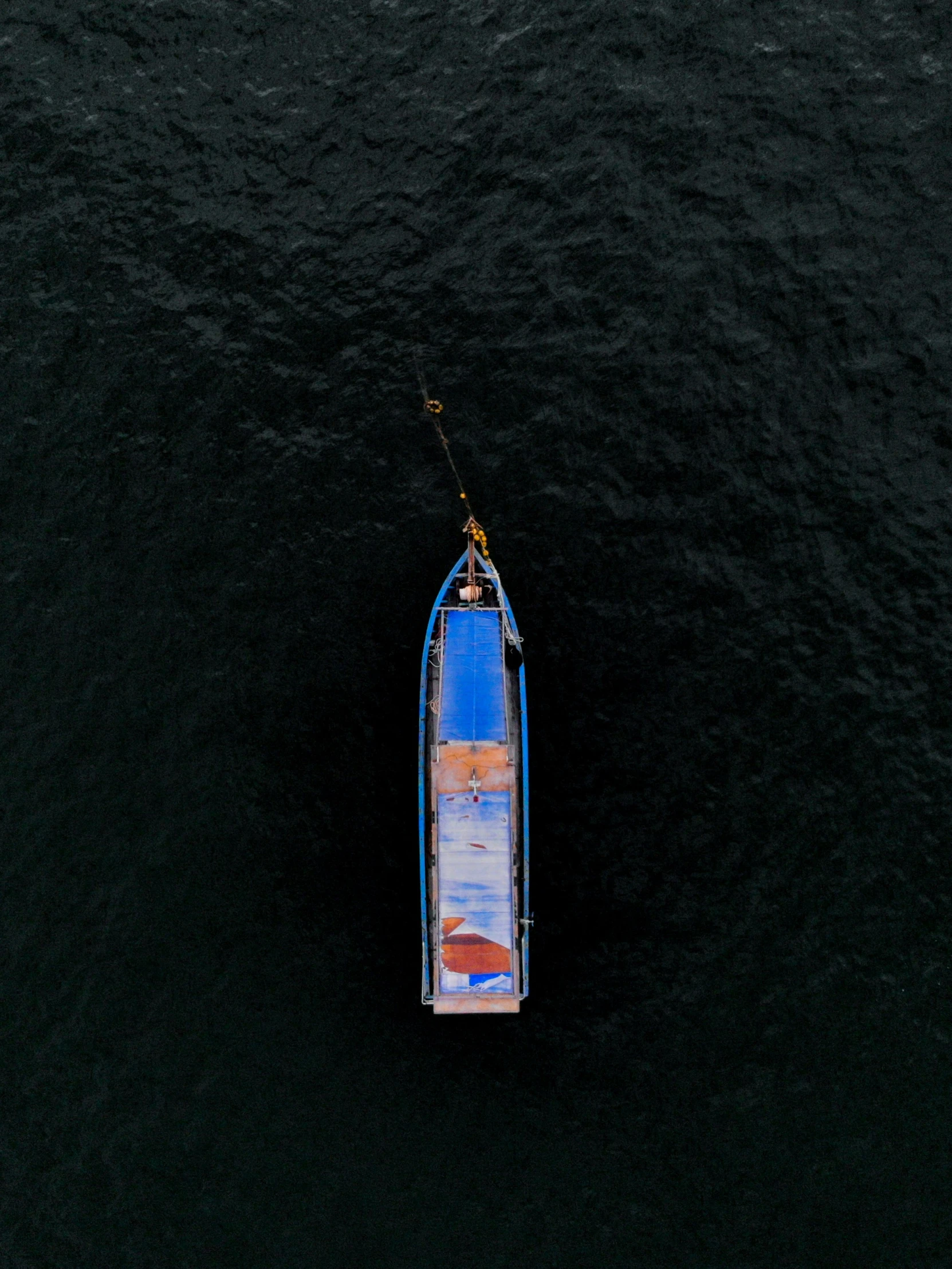 a small blue boat sitting on top of water