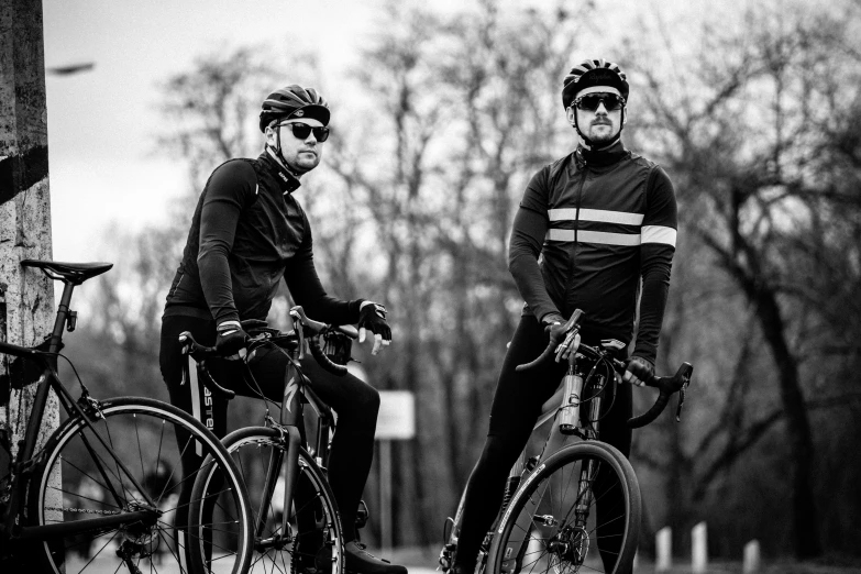 two cyclists are riding their bikes through the park