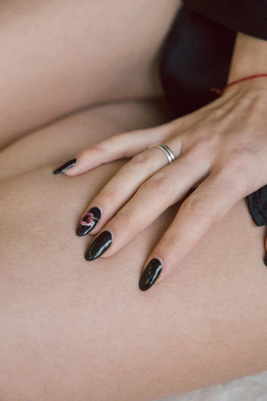 a close up of a person with black manies and celets on their hands