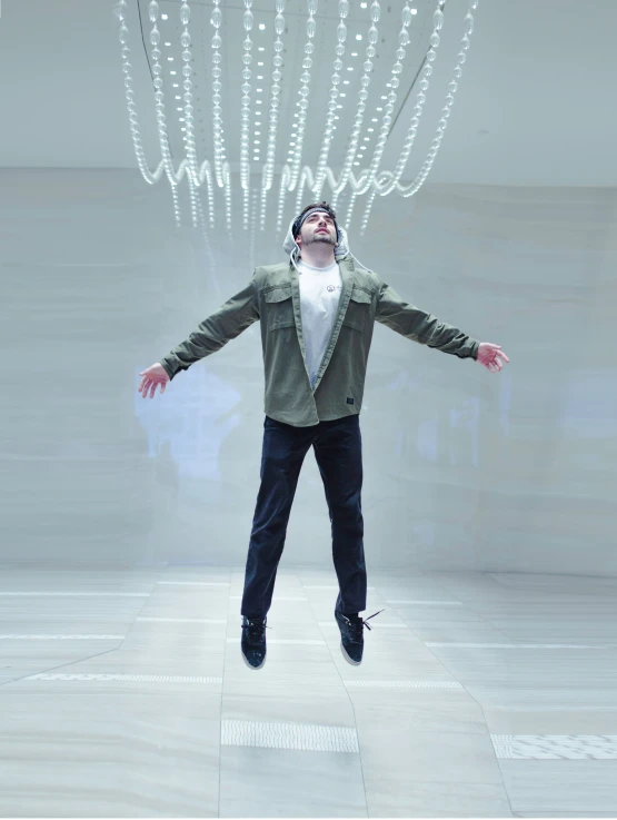 man jumps in air with long flowing lights hanging from head