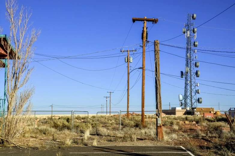 a tennis court in a desert, surrounded by power lines
