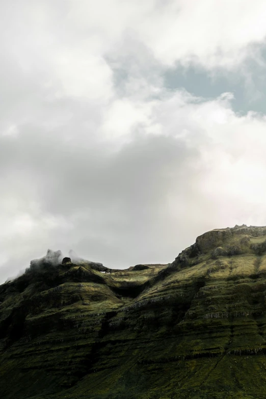 the side of a mountain, with grass growing on it