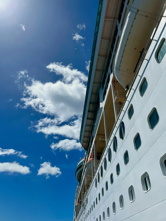 view of large cruise ship on clear blue day with sun beaming through the windows