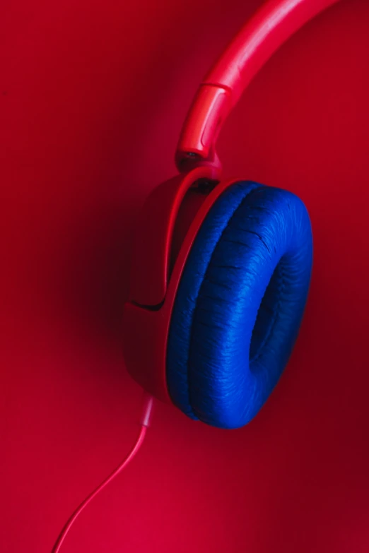 blue headphones on a red background with cord