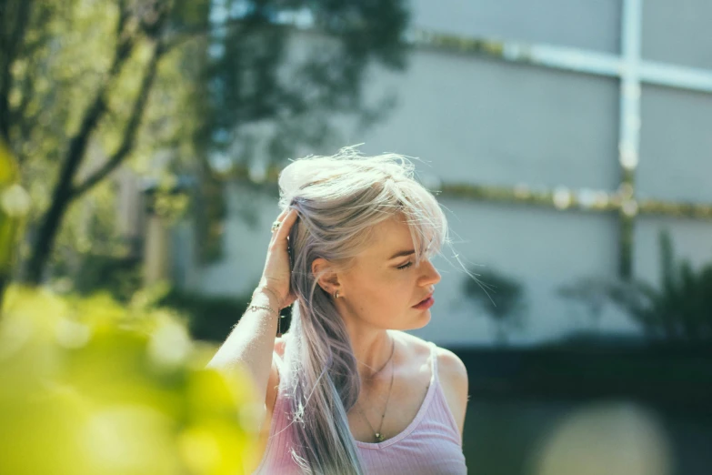 a girl with light pink hair standing outside in a back yard