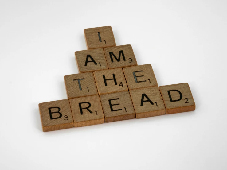 scrabble letters and words on a white surface with the words i am the bread