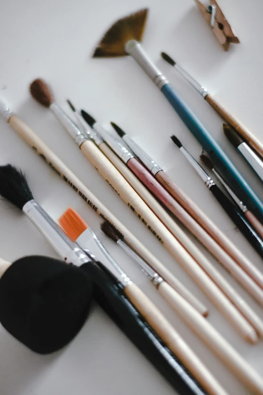 various brushes laying next to each other in the middle of a white table