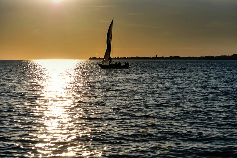 a sailboat with two sails is seen from the water