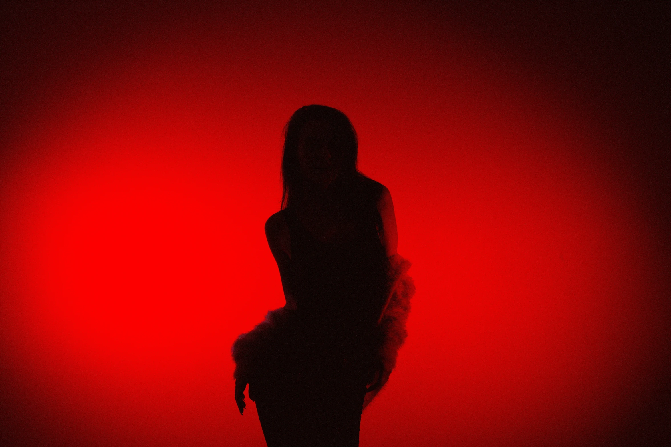 a woman standing in front of a red background