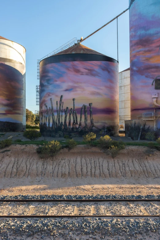 several big metal tanks with some very cool artwork on them