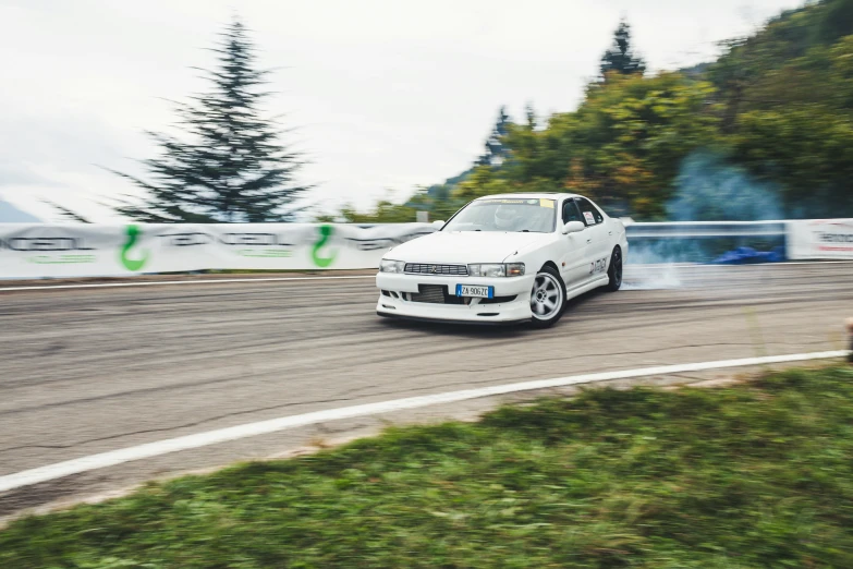 a white car is kicking up blue flames