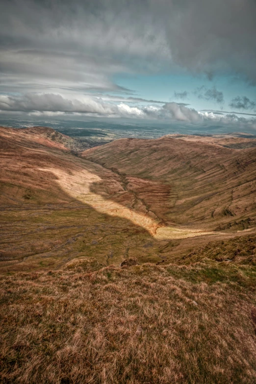 a lone bench on top of a hill near some water