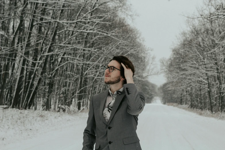 a man is standing in a wooded area talking on a cellphone