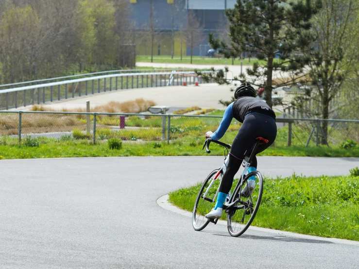 a bicyclist rides through a paved park lane