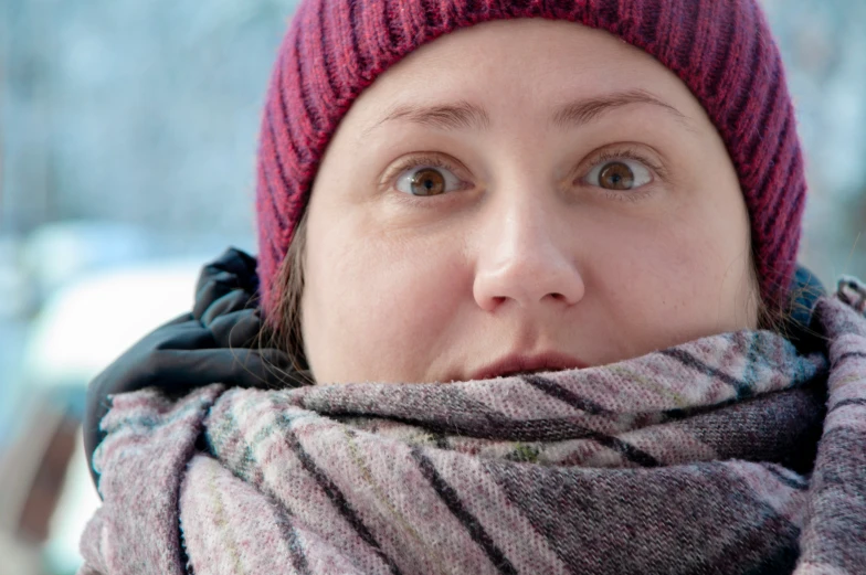 a woman with an over sized scarf and a red hat