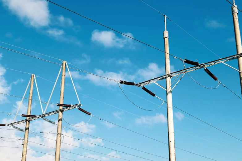 a row of tall electrical lines under a blue sky