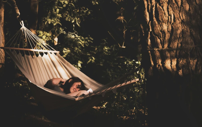 two people laying in a hammock looking at each other