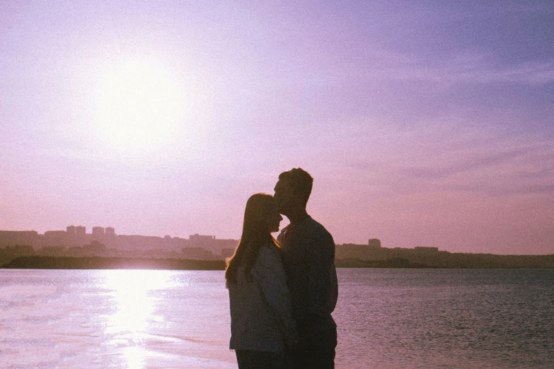 silhouette po of couple standing close together near a lake