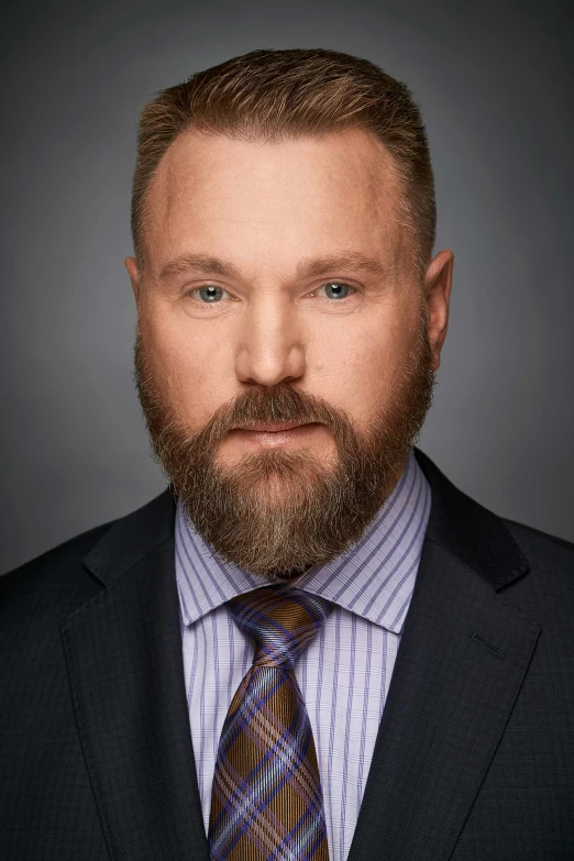 the man with a long beard is wearing a suit and striped tie