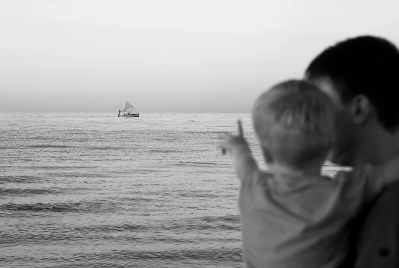 two people standing on the water near a boat