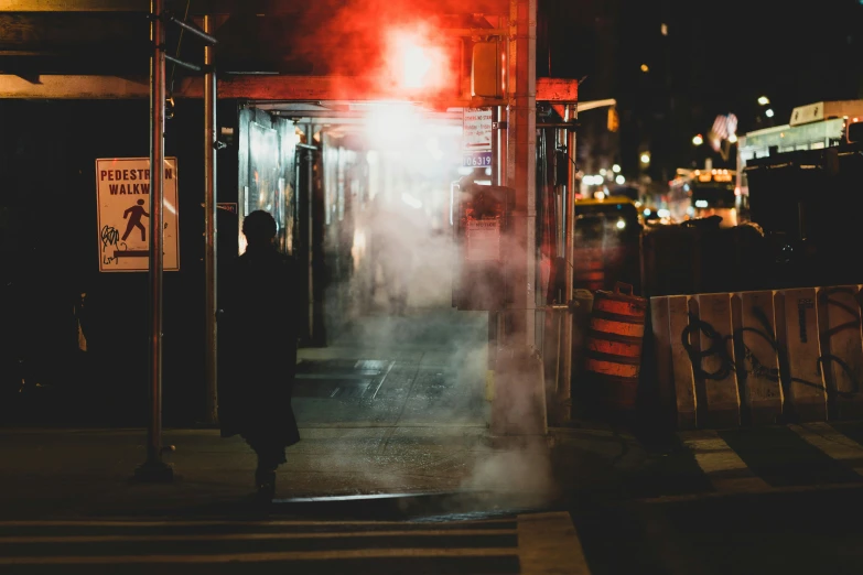 people walking on a street corner with smoke coming out the top of the buildings