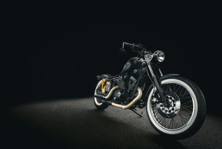 the motorcycle is in the dark with black background