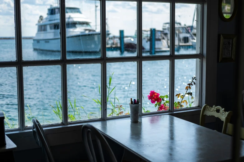 a window with the view of a boat in the water