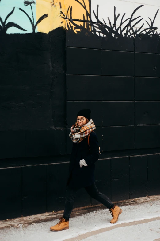 woman in a hat and scarf walking down the street