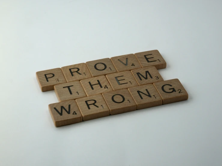 the word prove them wrong is written on scrabble tile