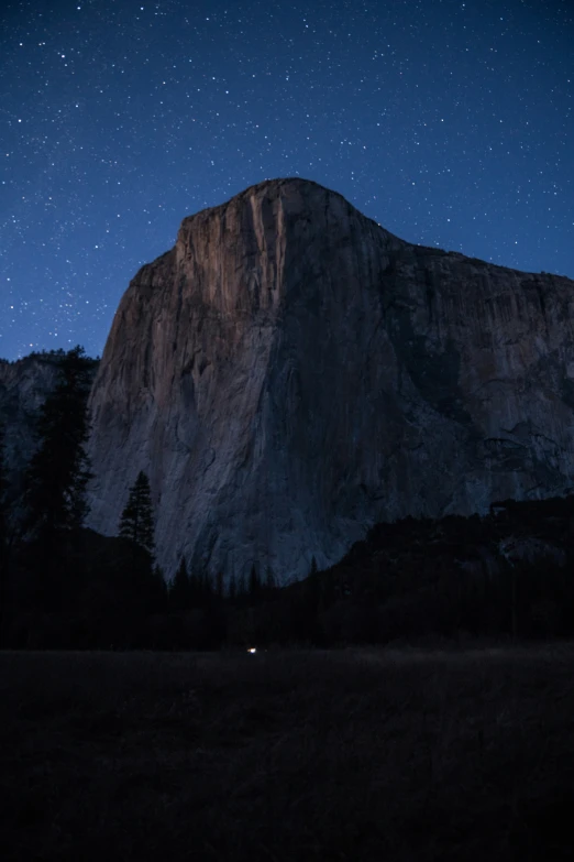 the night sky with stars in the middle of a mountain