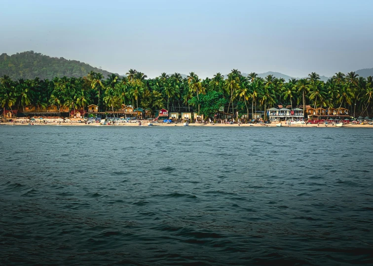 there is a boat out in the water and houses on a beach