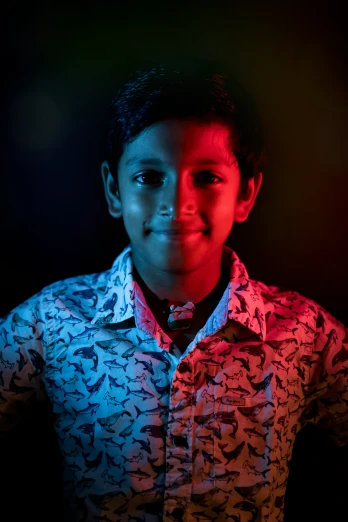 a young child with red and blue light coming from behind his face