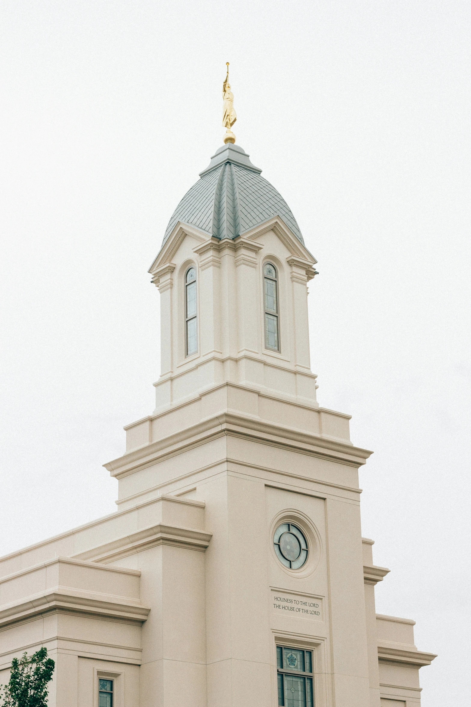 a white building with a gold statue on top of it