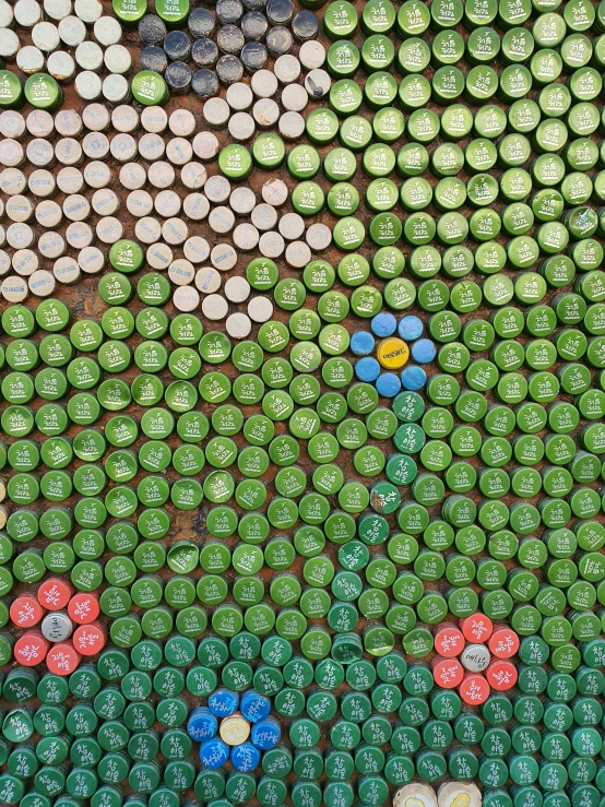 bottles with colorful flowers are arranged as a wall