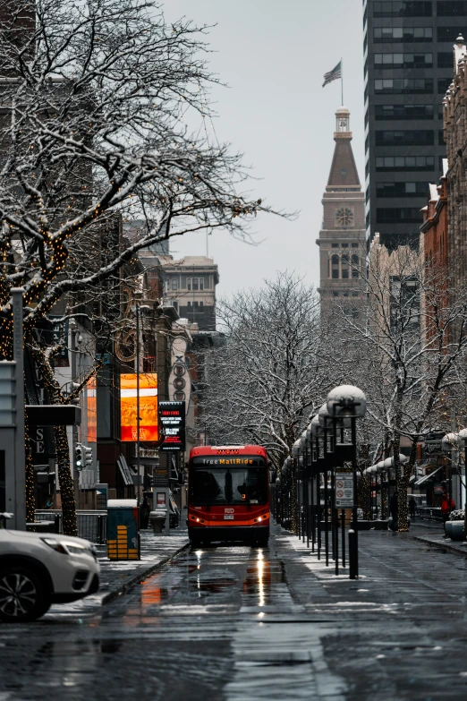 a red bus is driving down a city street