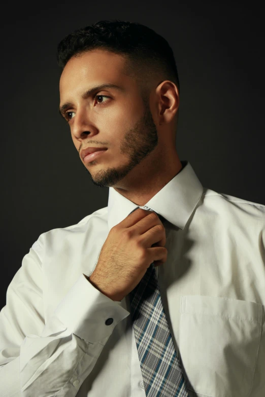 a man with black hair wearing a white dress shirt and tie