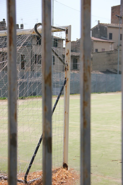 the gated goal post has been rusted and has a soccer ball in it