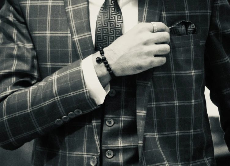 a man in a suit adjusts his tie on his collar