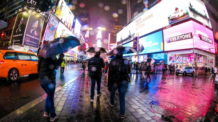 people walking on the street in a large city at night