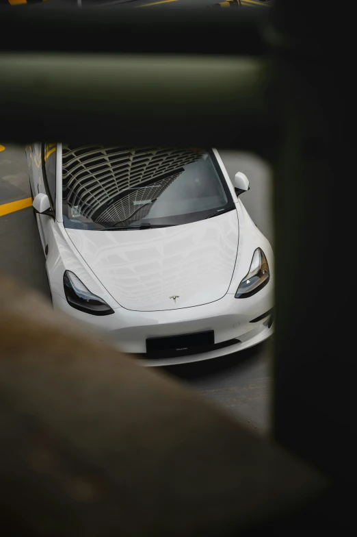 a white car parked on the street next to a fence