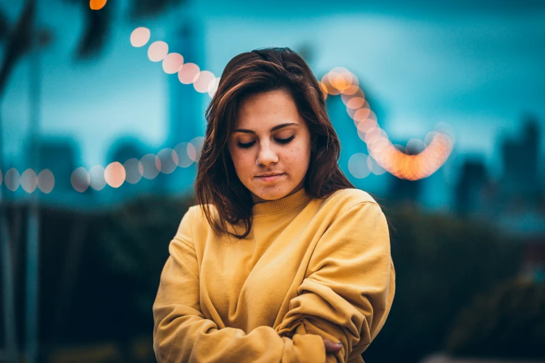 a beautiful woman in a yellow sweater with her arms crossed