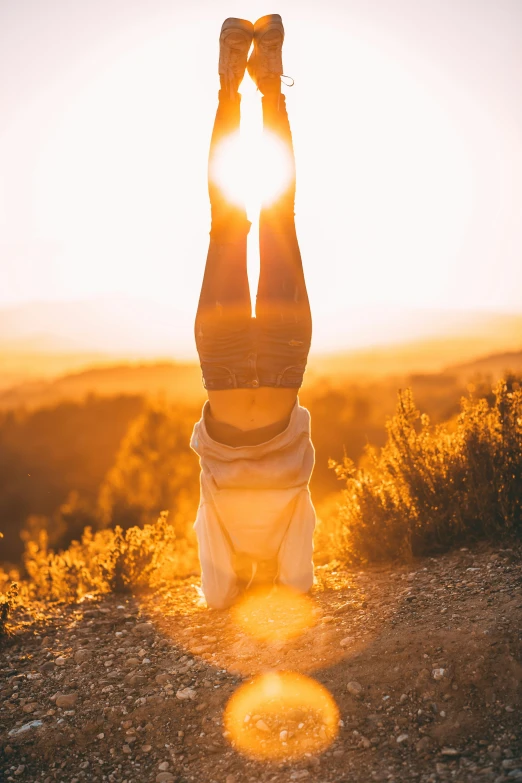 a person laying upside down on their back with the sun glaring over them