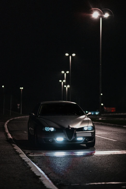 this is a car parked in front of the street lights at night