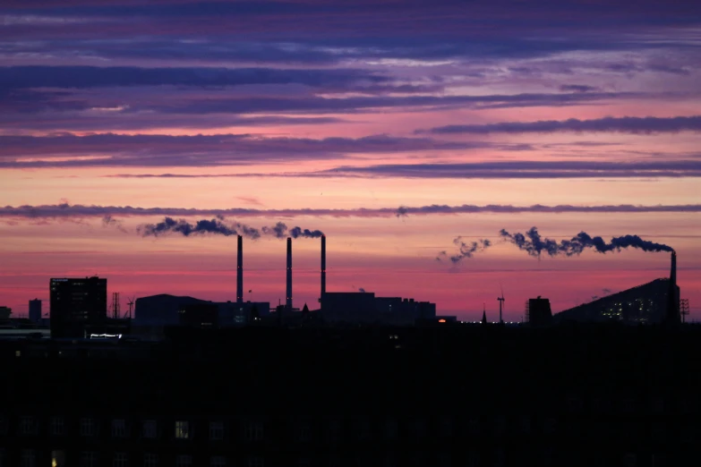 factory chimneys against a colorful sky and dusk