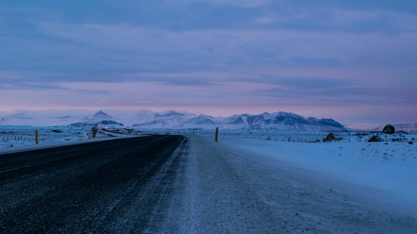 a long empty road during winter on a mountain side